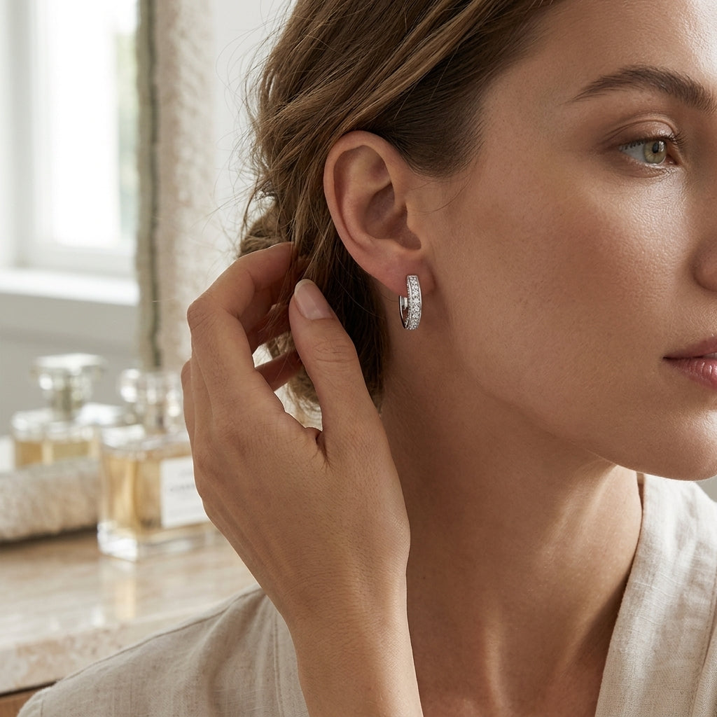 Woman touching a 0.56 CTTW moissanite hoop earring near a sunlit window