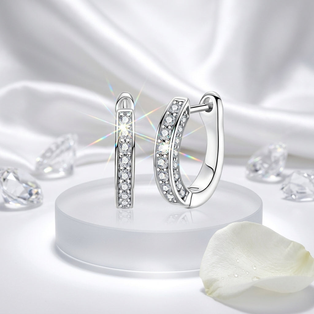 Sterling silver moissanite hoop earrings displayed on white satin with crystal accents