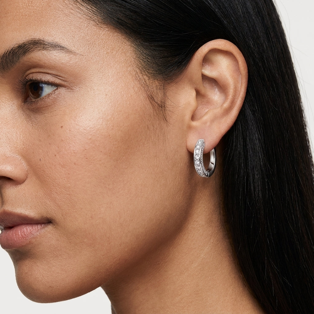 Woman wearing polished silver moissanite hoop earrings in a close-up view