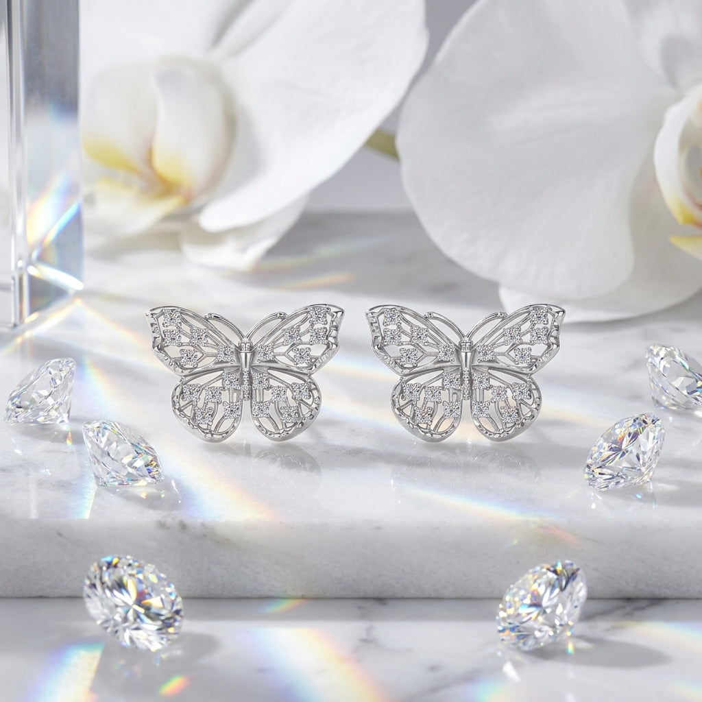 Butterfly moissanite stud earrings displayed with white orchids and crystal accents