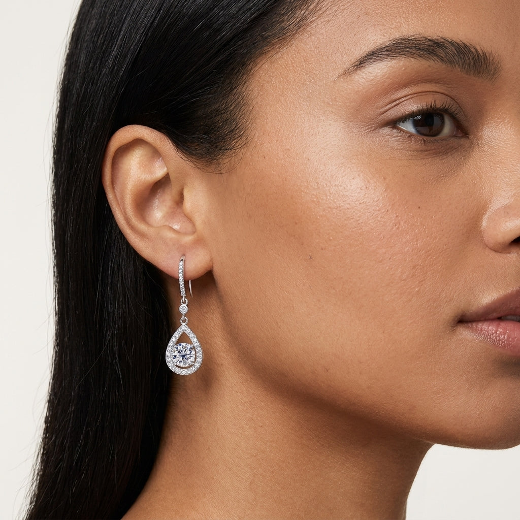 Woman wearing a teardrop moissanite dangle earring in a close-up portrait