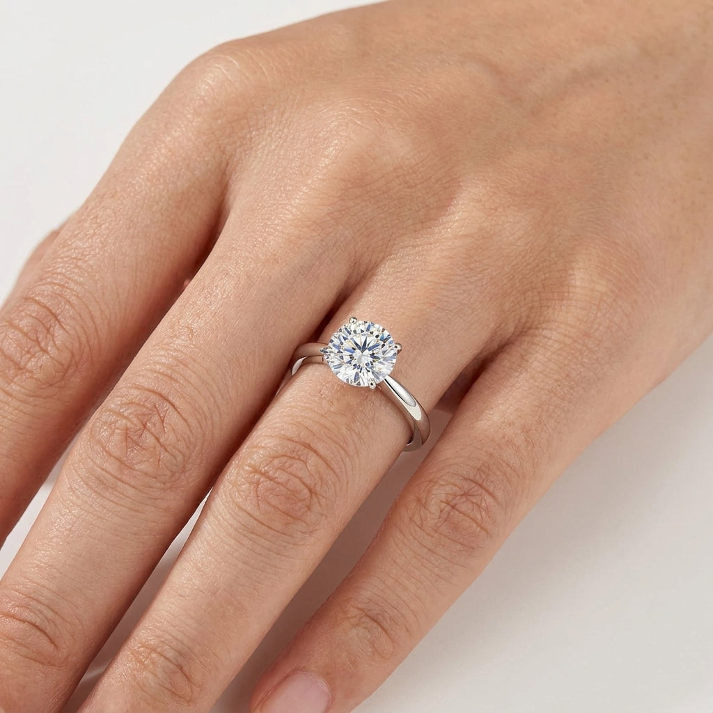 Close-up of a round moissanite engagement ring worn on the hand