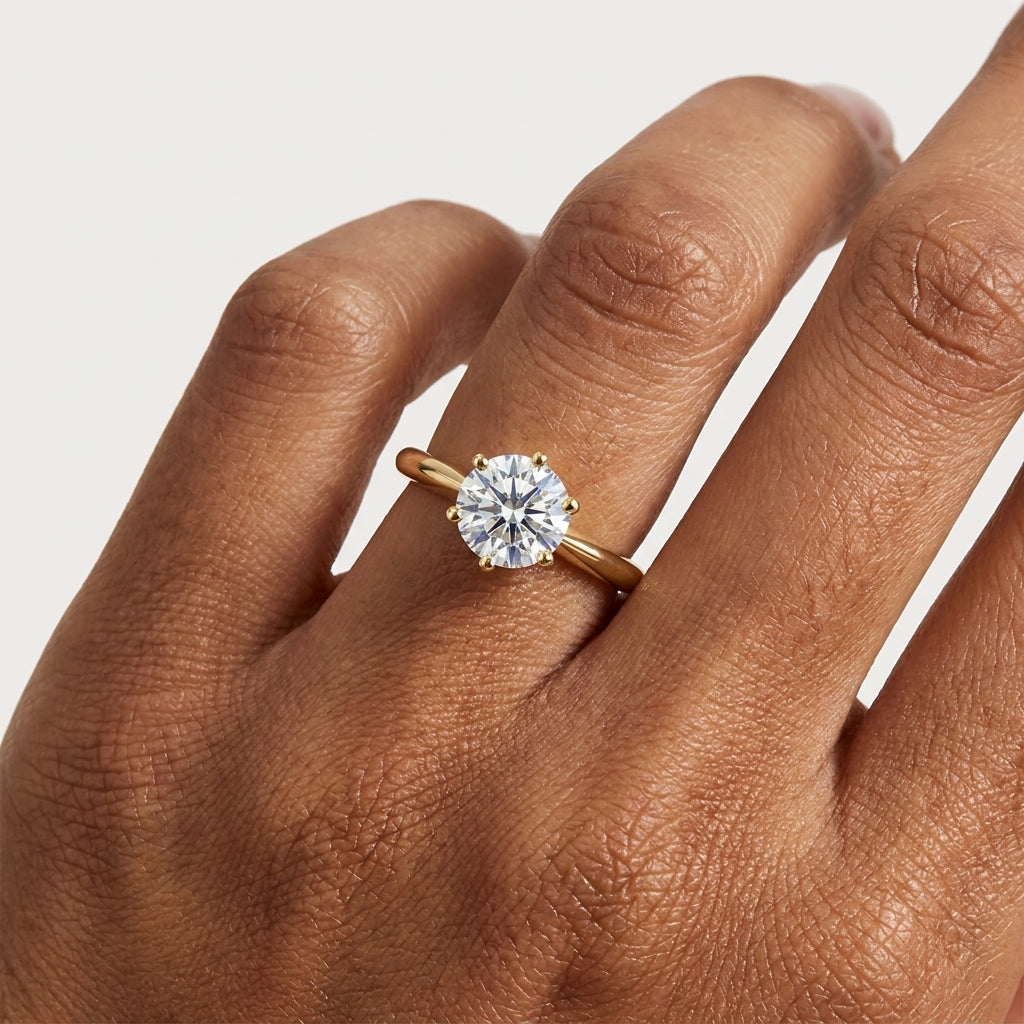 Close-up of a round moissanite solitaire ring in a six-prong gold setting