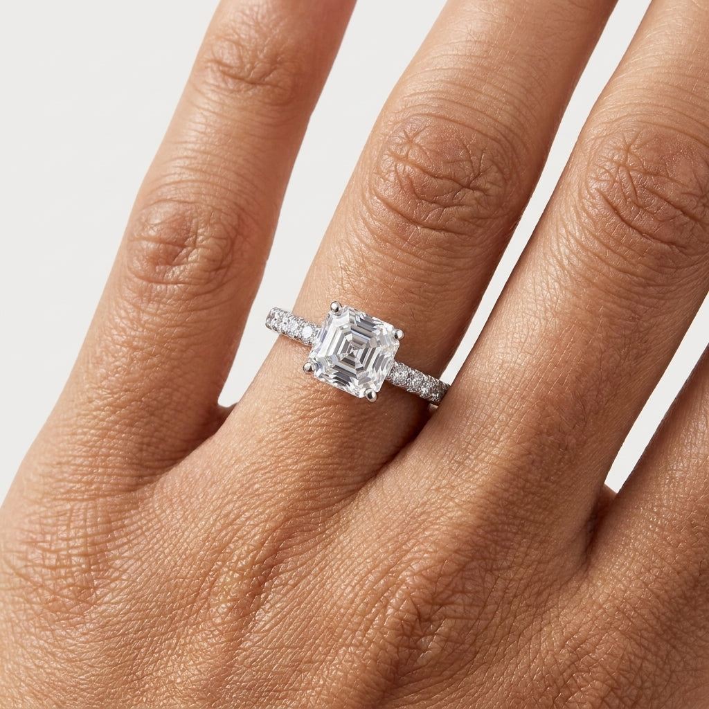 Close-up of an Asscher-cut moissanite engagement ring worn on the hand