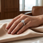 Asscher-cut moissanite engagement ring worn on a hand resting on champagne satin