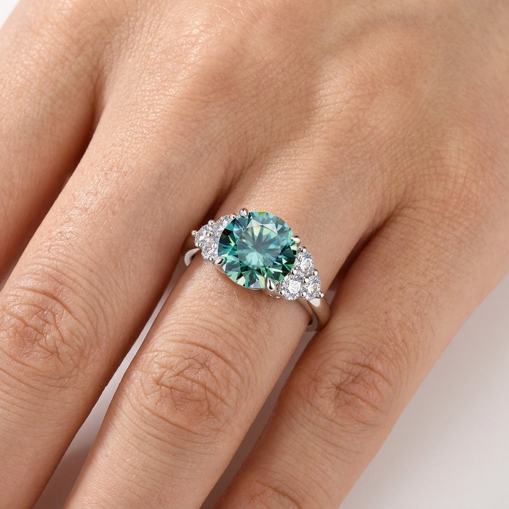 Green moissanite engagement ring worn on a woman’s hand