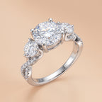 4.25 CTTW three-stone round-cut moissanite engagement ring in sterling silver on a beige background.
