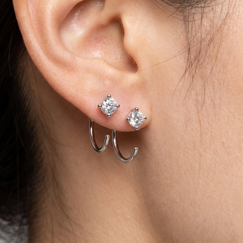 Close-up of 4MM moissanite hoop earrings worn with additional stud earrings