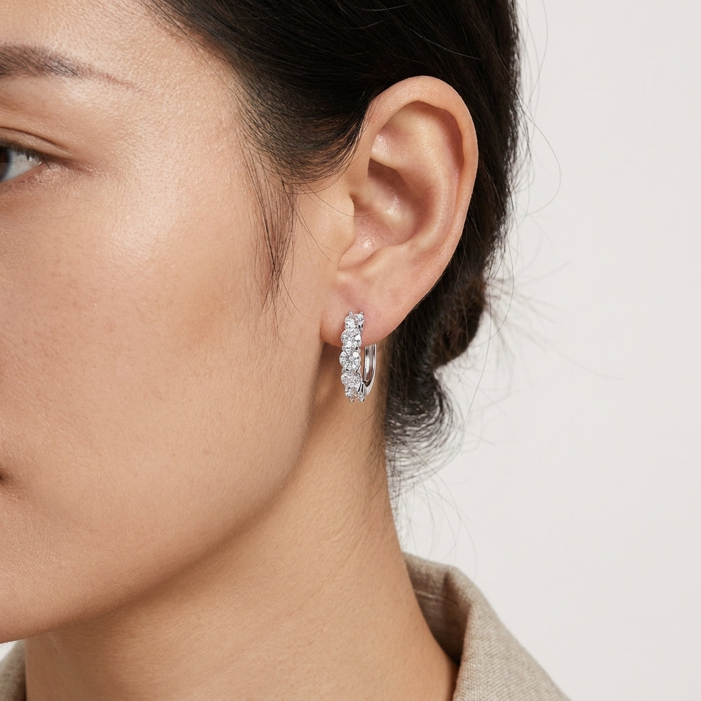 Woman wearing a five-stone moissanite hoop earring against a neutral background