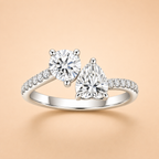 Two-stone moissanite engagement ring with round and pear-cut stones and pavé shoulders