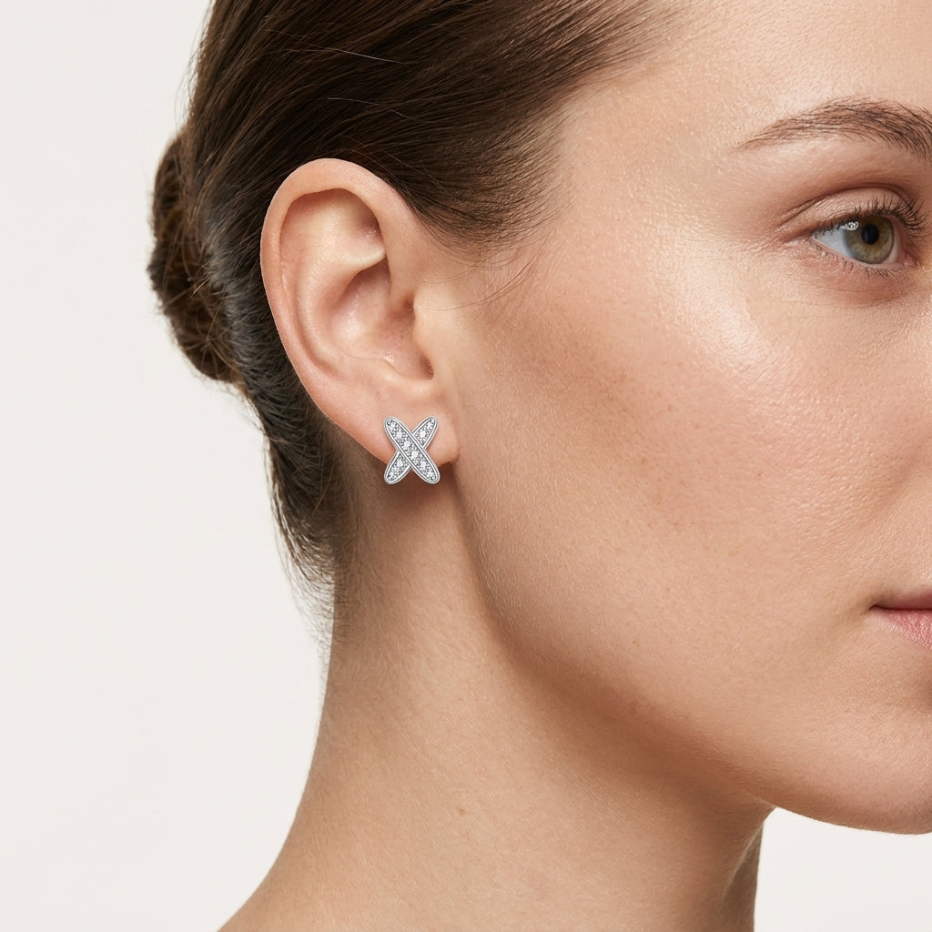 Close-up of a woman wearing an X-shaped moissanite cross stud earring