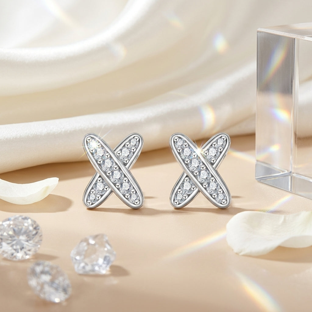 Moissanite cross stud earrings displayed on cream satin with crystals and flower petals