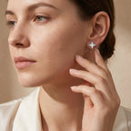 Woman touching a sparkling four-leaf moissanite stud earring