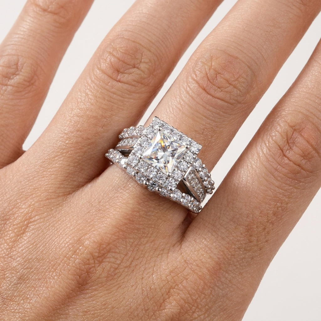 Close-up of a princess-cut moissanite halo ring worn on the hand