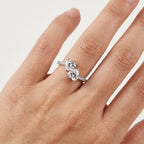 Close-up of a twin-stone moissanite engagement ring worn on the hand
