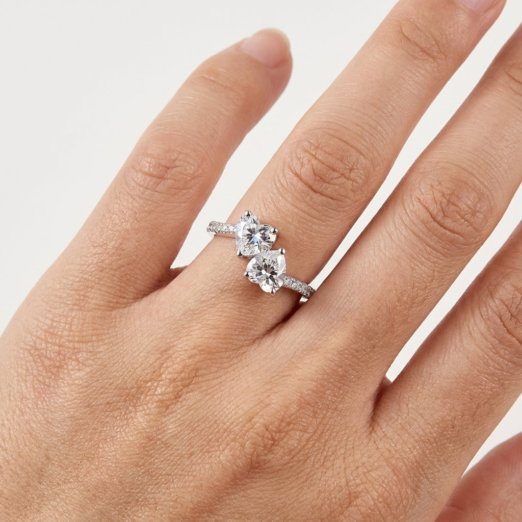 Close-up of a twin-stone moissanite engagement ring worn on the hand