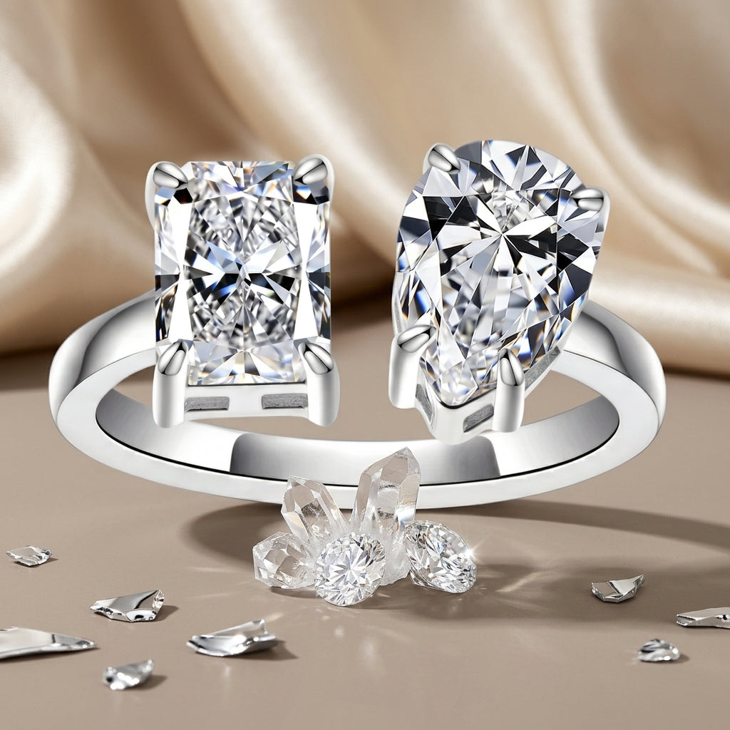 Radiant and pear-cut moissanite engagement ring displayed with crystals on champagne satin