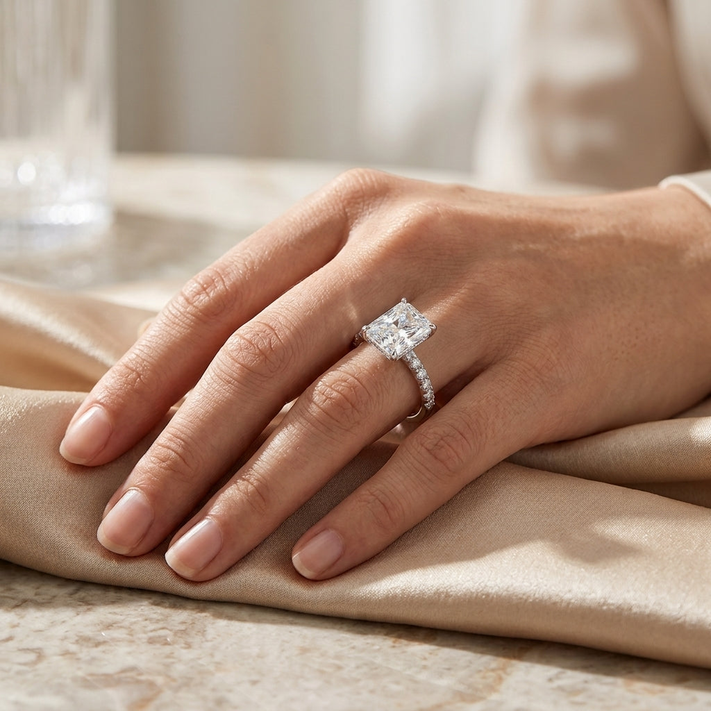 Radiant-cut moissanite pavé engagement ring worn on a hand