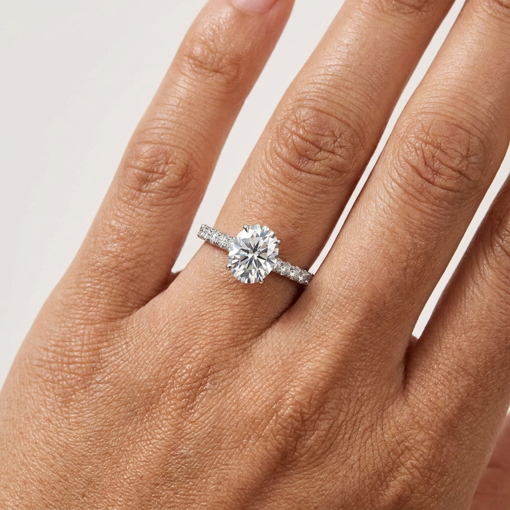 Close-up of a 2 CT oval-cut moissanite engagement ring worn on the hand.